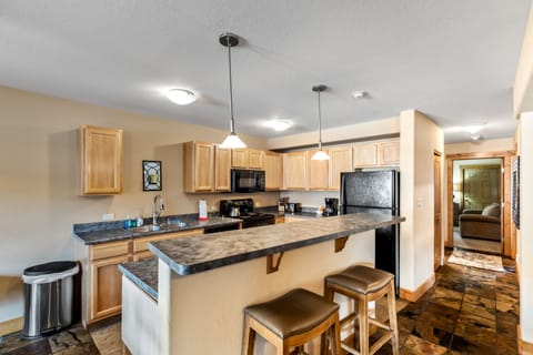 Two bar stools and a fully equipped kitchen.
