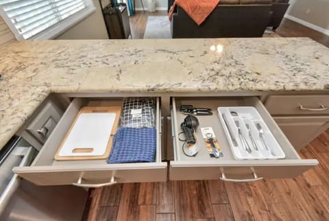 The kitchen is stocked with all the essentials... dishes, utensils, pots & pans.