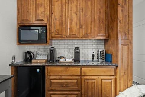 Kitchenette complete with bar sink, microwave, mini fridge, and coffee/tea bar
