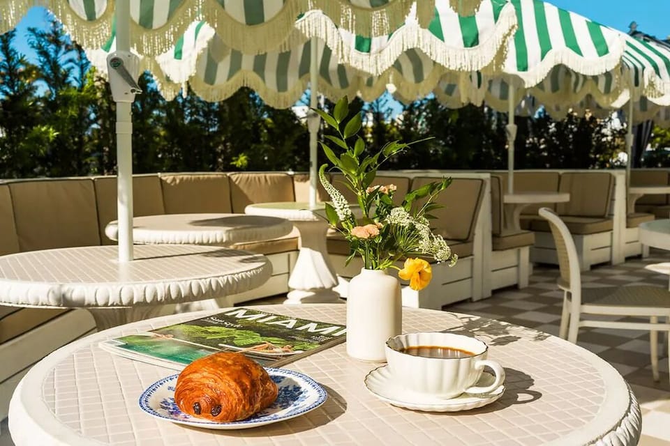 Savor morning coffee and pastries under chic striped umbrellas.