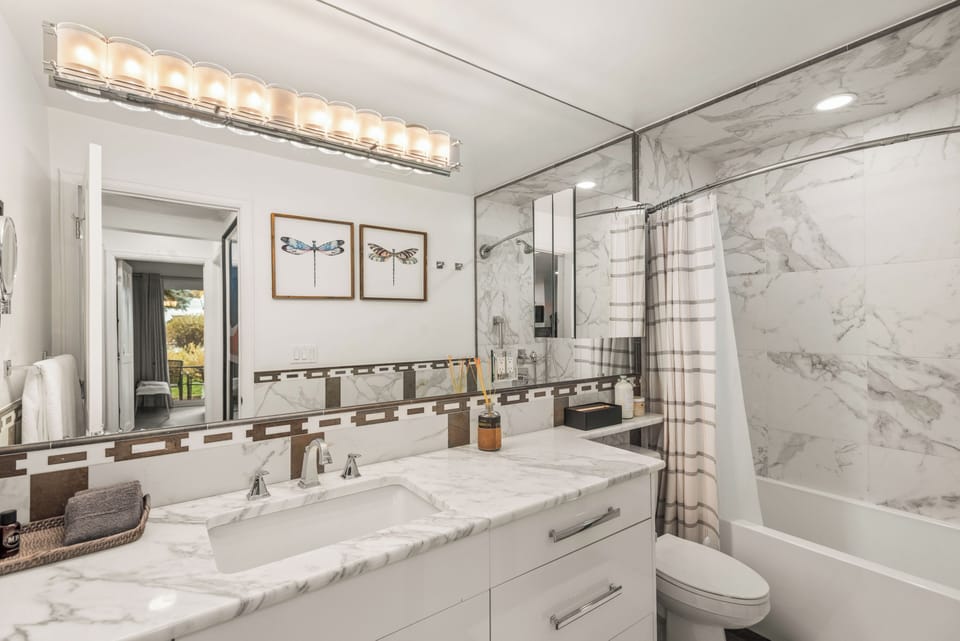Bathroom with tub/shower combo and spacious vanity.