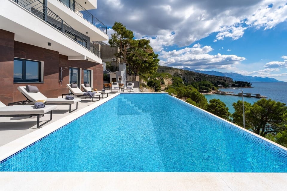 A spacious terrace on the property of a fully fenced Croatian villa for rent and comfortable deckchairs for sunbathing